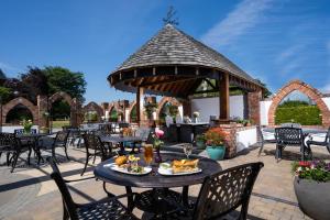 纽卡斯尔Burrendale Hotel Country Club & Spa的一个带桌椅的庭院和一个凉亭