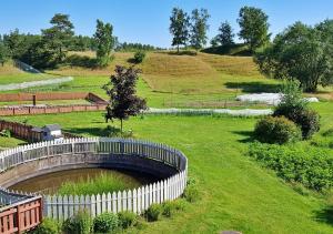 阿灵索斯Flora Dekor gästgård的绿色田野中带白色围栏的花园