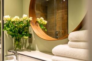 约克The Boutique York Garden Studio的浴室设有镜子和花瓶,位于水槽上