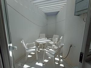 古莱比耶Maison S+1 très bien équipée à 2mn de la plage的一间配备有白色椅子和桌子的用餐室