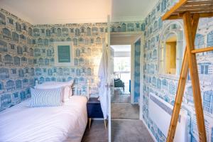 亨斯坦顿Apartment 4, Hunstanton的卧室拥有蓝色和白色的墙壁,配有一张床