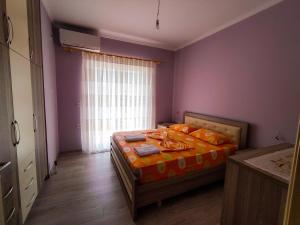 吉诺卡斯特Cheerful 2 bedroom villa with free parking.的一间卧室配有带橙色床单的床和窗户。