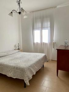 普雷甘齐奥尔Casa Ester的白色的卧室设有床和窗户