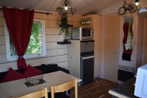 耶尔mobil-home sur terrain bucolique的厨房以及带桌子和微波炉的客厅。