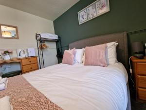 塔博雷The Foresters Arms的一间卧室配有带粉色和白色枕头的床