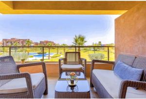马拉喀什Marrakech golf city prestigia的门廊设有藤椅和美景桌子