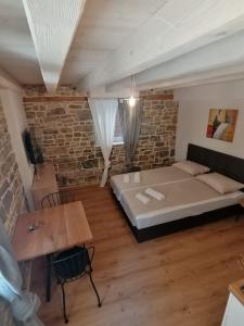 皮兰GG art apartments II的一间卧室设有一张床和砖墙