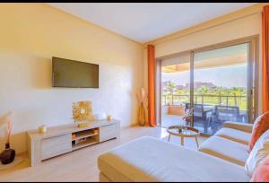 马拉喀什Marrakech golf city prestigia的客房设有床、电视和沙发。