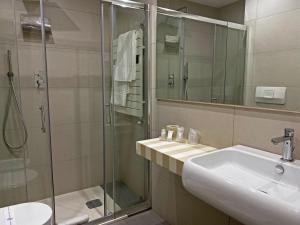 阿韦利诺阿韦利诺维瓦酒店的一间带水槽和玻璃淋浴的浴室