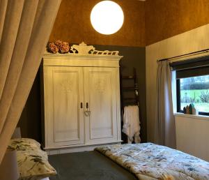 玛塔玛塔Cosy Country Stay B&B的卧室配有白色橱柜和窗户。