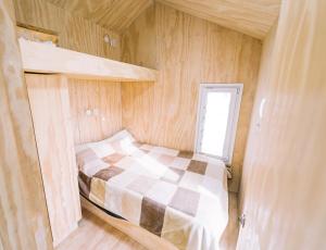 巴尔内阿利奥埃尔康多尔Loyca Eco-Tiny House的一间小卧室,小房子里配有一张床