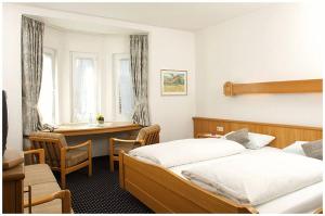 林登贝格拜耶里斯彻酒店的一间卧室配有两张床和一张书桌