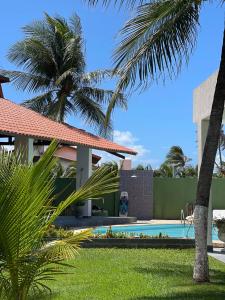 卡姆布库Pousada Kite Da Mary Cumbuco的一座别墅,设有游泳池和棕榈树