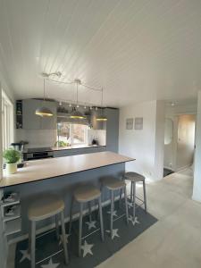 Årsta HavsbadModern cottage in Årsta Havsbad Stockholm, Sweden的厨房配有带凳子的大柜台。