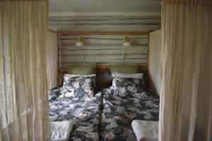 Lilla EdetEsperöd Farm的床上床,带窗帘和床罩