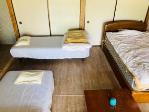 日南Guesthouse Nichinan - Vacation STAY 82913v的客房设有两张床和一张木桌。