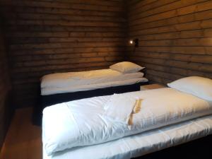 亨宁斯韦尔菲斯克罗根罗布尔酒店的木墙客房内的2张白色床