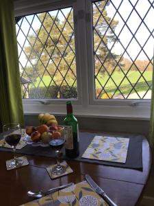 麦克尔斯菲尔德Round-y-Corner的一张桌子,上面放着一瓶葡萄酒和一碗水果