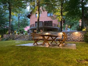 布雷佐维察Sky Villa Brezovice的房屋前的野餐桌和长凳