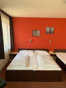 佩奇City Hotel Agoston的橙色墙壁间的一张床位