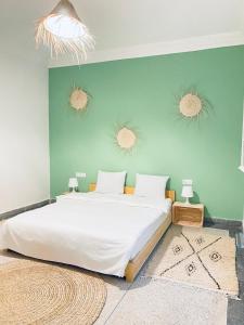 索维拉WELKAM Home & Coworking的一间卧室设有一张大床和绿色的墙壁