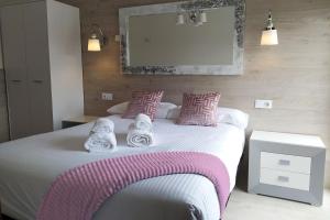 金塔纳尔德拉谢拉Camino del Pinar的卧室配有带粉色和白色枕头的大床