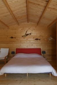FronsacCABANE BAMBOU的卧室配有木制天花板上的床铺