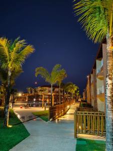 塞古罗港Apartamento Ondas Praia Resort的晚点在建筑物旁边一排棕榈树