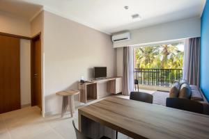 塞古罗港Apartamento Ondas Praia Resort的客厅设有餐桌和电视
