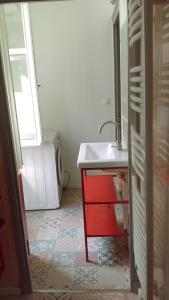 洛什Loches : gîte de charme indépendant avec jardin的一间带水槽和红色橱柜的浴室