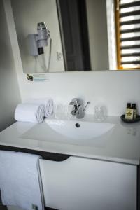 拉尔邦克La Tissandière的白色浴室水槽、镜子和毛巾