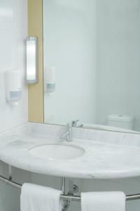 埃莫西约宜必思埃莫西酒店的白色浴室水槽、镜子和毛巾