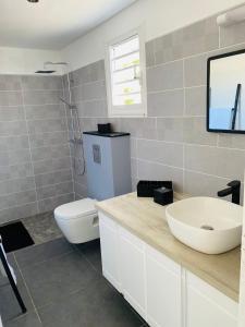 拜马欧K'Noly的一间带水槽和卫生间的浴室以及一台电视。