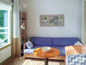 Floda5 person holiday home in FLODA的客厅配有蓝色的沙发和桌子