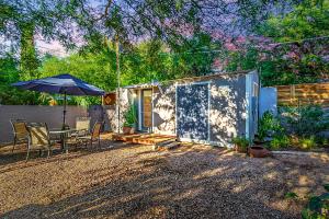 土桑Peaceful Tucson Tiny House Getaway with Backyard的一个带桌子和雨伞的小房子