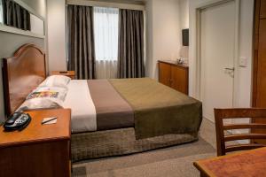 悉尼悉尼南部大酒店的酒店客房配有一张床、一张书桌和电话