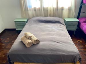 坎伯雷塔Hostel Planeta Cumbrecita的一张带两张毛巾的床和两张桌子