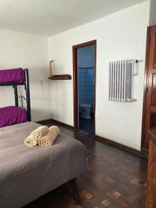 坎伯雷塔Hostel Planeta Cumbrecita的一间卧室配有带毛巾的床