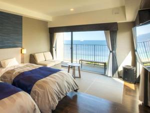 别府REX HOTEL Beppu的一间卧室配有一张床,享有海景