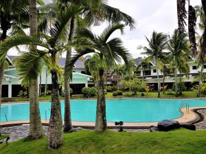 卡兰巴Chateau Bleu Resort的一座楼前棕榈树游泳池