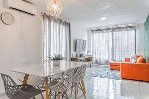 坎昆Pako Stays - Luxurious & Spacious 2 Bedroom Apartments Close to the Beach, Free Wi-Fi, Ideal Location in Downtown Cancun Centro的客厅配有桌椅和沙发