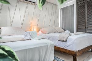 坎昆Pako Stays - Luxurious & Spacious 2 Bedroom Apartments Close to the Beach, Free Wi-Fi, Ideal Location in Downtown Cancun Centro的两张睡床彼此相邻,位于一个房间里