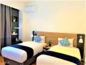 卡兰巴Chateau Bleu Resort的两张睡床彼此相邻,位于一个房间里