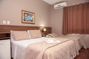 ArcosCAMBRAIA HOTEL ARCOS的一间卧室配有一张床,床上有毛巾