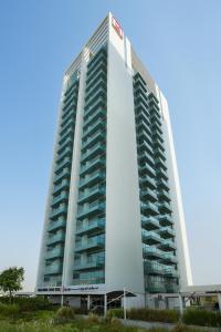 迪拜Millennium Executive Apartments Mont Rose的一座高大的白色建筑,有许多阳台