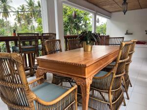 龙目岛库塔Naia Lombok的一间带木桌和椅子的用餐室