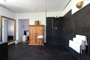 康斯坦茨Konstanzer Ferienwohnungen的带淋浴和黑色瓷砖的浴室