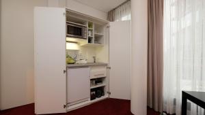 波恩Wissenschaftszentrum Bonn的厨房配有白色橱柜和窗户