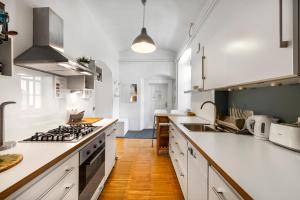 卢布尔雅那ROG Apartment with Furnished Courtyard的厨房配有白色橱柜和炉灶烤箱。