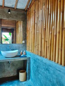 吉利阿尔Musa Bintang Villas and Bungalows Gili Air的一间带水槽和木墙的浴室